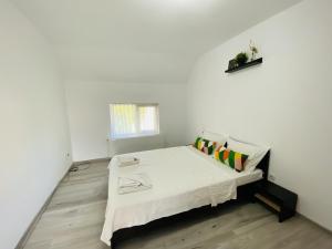 um pequeno quarto branco com uma cama num quarto em Central Apartment with Garden in Blaj em Blaj