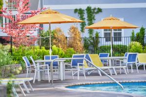 a group of chairs and tables with umbrellas next to a pool at Lithia Springs Resort in Ashland