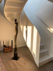 a room with a staircase and a vase on the floor at Penthouse am Südstrand - Kamin, Dachterrasse mit Meerblick und Gasgrill, Luxus-Design-Apartment, 2 Minuten zum Strand, Klimaanlage in Binz