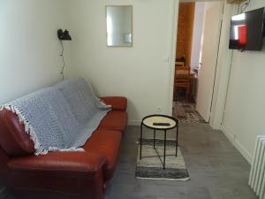 - un salon avec un canapé en cuir brun et une table dans l'établissement Charmant studio en centre-ville, à Boulogne-sur-Mer