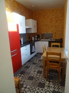 Il comprend une cuisine équipée d'une table en bois et d'un réfrigérateur rouge. dans l'établissement Charmant studio en centre-ville, à Boulogne-sur-Mer