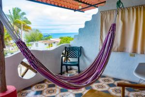 a hammock in a room with a view of the ocean at Royal Galápagos Inn in Puerto Baquerizo Moreno