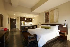 a bedroom with a large white bed and a kitchen at The Marmara Park Avenue in New York