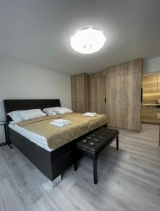 a bedroom with a bed and a bench in it at Smart Apartment l in Huncovce