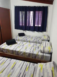 2 letti singoli in una camera da letto con finestra di Casa Doña Isabel a Puerto Iguazú
