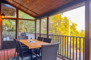 una veranda con tavolo e sedie in legno su una terrazza di Luxury Adirondack Lakeview a Gilford