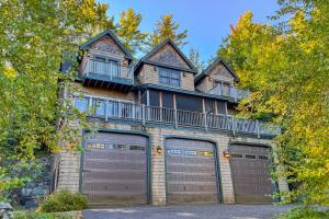 una grande casa con due porte garage davanti di Luxury Adirondack Lakeview a Gilford