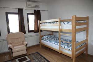 1 Schlafzimmer mit 2 Etagenbetten und einem Stuhl in der Unterkunft HSH Apartments in Sarajevo
