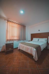 a bedroom with a large bed and a wooden floor at EL MANÁ in Huarmey