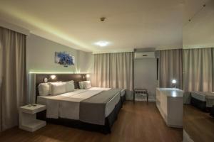 um quarto de hotel com uma cama grande e um lavatório em Hotel WZ Jardins em São Paulo