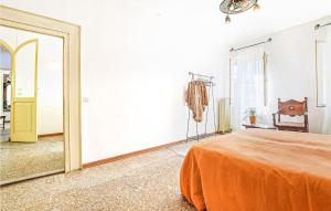 ein Schlafzimmer mit einem orangenen Bett und einem Spiegel in der Unterkunft Beautiful Apartment In Feltre With Kitchen in Feltre