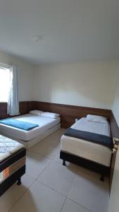 1 dormitorio con 2 camas y ventana en Dream House en Itacimirim