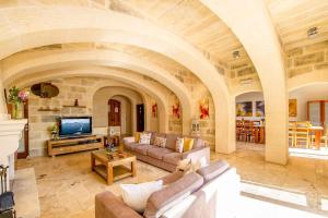 sala de estar amplia con sofá y TV en Dream by Hamlet Holiday Home en Għasri