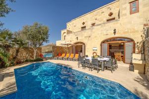 Casa con piscina con mesa y sillas en Dream by Hamlet Holiday Home, en Għasri