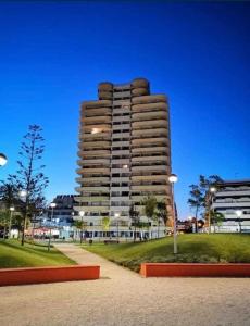 un grand bâtiment avec un parc en face dans l'établissement Sunset Lover Aparthotel Guadiana, à Monte Gordo