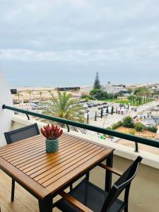 uma mesa e cadeiras numa varanda com vista para a praia em Sunset Lover Aparthotel Guadiana em Monte Gordo