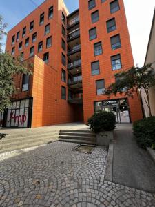 - un bâtiment en briques rouges avec un escalier devant dans l'établissement Grande Veranda 2, à Tirana