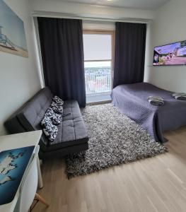 a living room with a couch and a bed and a window at Penthouse in the Oulu center in Oulu