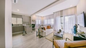 a living room with a couch and a table at Fully Serviced Apartment at Regatta Living II - 907 in Santo Domingo