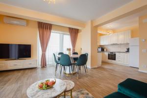 uma sala de estar com mesa e cadeiras e uma cozinha em Grand Panorama City Views em Oradea
