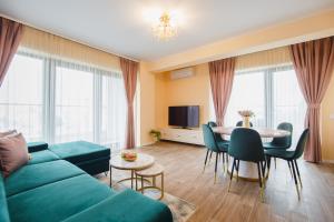 uma sala de estar com um sofá verde e uma mesa em Grand Panorama City Views em Oradea