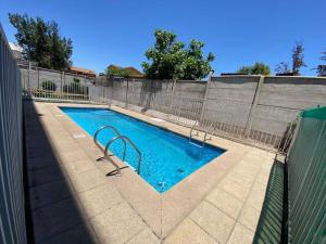 a swimming pool with a fence around it at Hermoso Depto Piscina Quincho in Rancagua