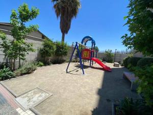 a playground with a slide and a swing at Hermoso Depto Piscina Quincho in Rancagua