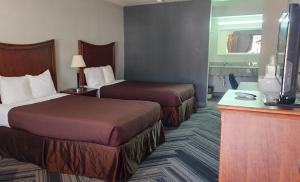 una camera d'albergo con due letti e una televisione di Raintree Inn ad Ada