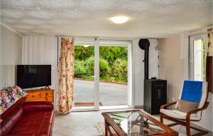 sala de estar con sofá, TV y ventana en Cozy Apartment In Chambornay-ls-pin With Outdoor Swimming Pool, 