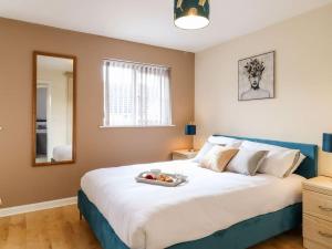 a bedroom with a large bed with a tray of fruit on it at Wisteria Place in Tiptree