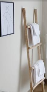 a wooden towel rack with towels on it in a bathroom at Amare Luxury Living in Volos