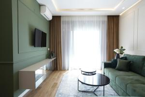 a living room with a green couch and a table at GRAND LUX APARTMENTS in Banja Luka