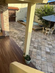 聖若澤迪里巴馬爾的住宿－Jane Farias，庭院配有桌椅和遮阳伞。