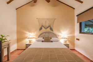 a bedroom with a large bed with two lamps at Hotel Colibri Beach in Playa del Carmen