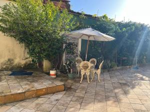 聖若澤迪里巴馬爾的住宿－Jane Farias，庭院配有桌子、遮阳伞和椅子