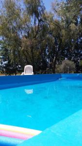 una silla blanca sentada junto a una piscina en Casa Quinta Los Prados en Río Tala
