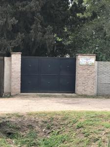 Una puerta negra con un cartel encima. en Casa Quinta Los Prados en Río Tala