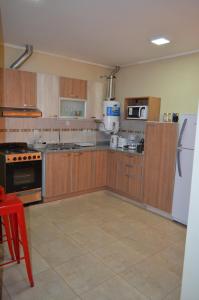 a kitchen with wooden cabinets and a white refrigerator at Susy Rental Depto N 1 in Malargüe