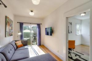 ein Wohnzimmer mit einem blauen Sofa in einem Zimmer in der Unterkunft Light filled Condo with enclosed sunny backyard in Oakland