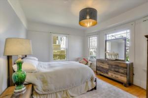 a bedroom with a bed and a table with a lamp at Light filled Condo with enclosed sunny backyard in Oakland