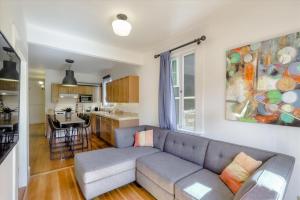 ein Wohnzimmer mit einem Sofa und einer Küche in der Unterkunft Light filled Condo with enclosed sunny backyard in Oakland