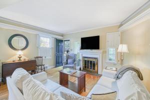 uma sala de estar com dois sofás brancos e uma lareira em The Little House em Annapolis