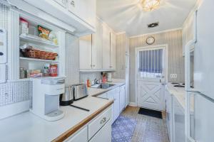 a kitchen with white cabinets and a white door at The Little House in Annapolis