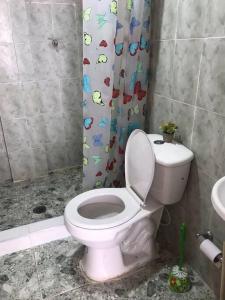 a bathroom with a toilet and a shower curtain at Donde Bris in Ríohacha
