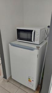 a microwave sitting on top of a refrigerator at Bahía Rental-Departamento x dia in Bahía Blanca +2 photos