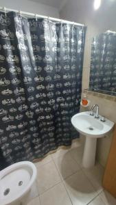 a bathroom with a sink and a shower curtain at Bahía Rental-Departamento x dia in Bahía Blanca