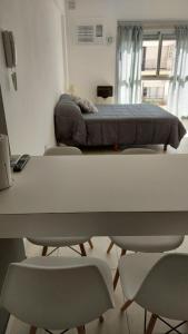 Habitación con cama, mesa y sillas. en Bahía Rental-Departamento x dia en Bahía Blanca