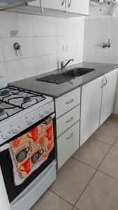 a kitchen with a stove and a sink at Bahía Rental-Departamento x dia in Bahía Blanca