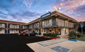 a hotel with a car parked in a parking lot at Motel 6-Rancho Cordova, CA - Rancho Cordova East in Rancho Cordova