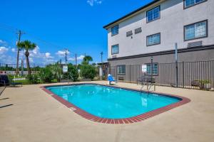 a large swimming pool in front of a building at Studio 6-Sulphur, LA in Sulphur